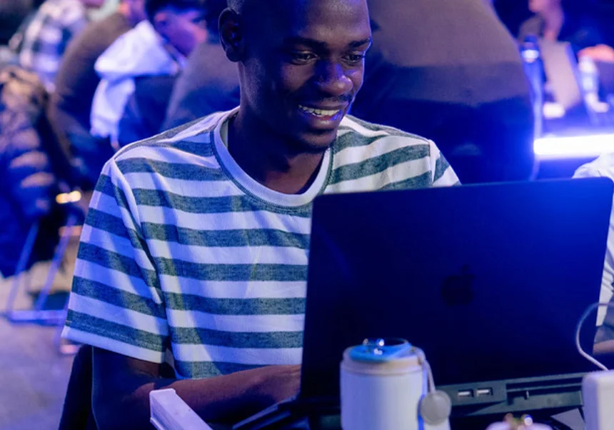 A hackathon participant coding on a laptop